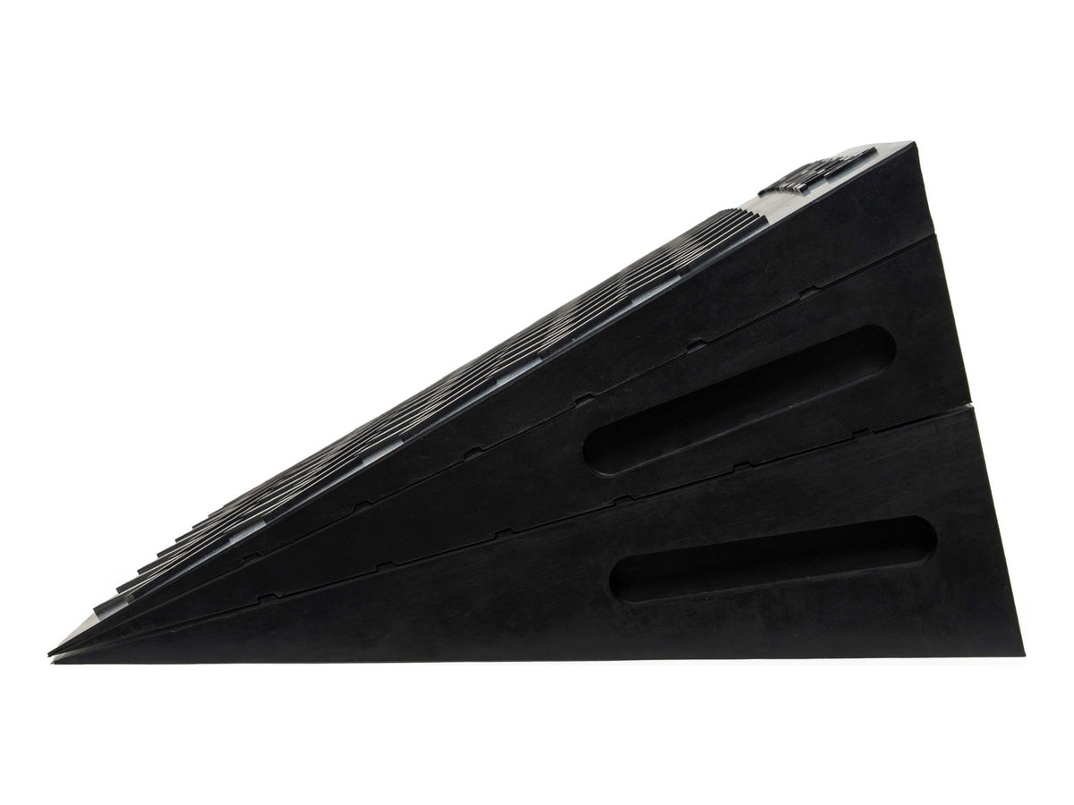 A set of black rubber vehicle ramp blocks stacked diagonally on a plain white background.