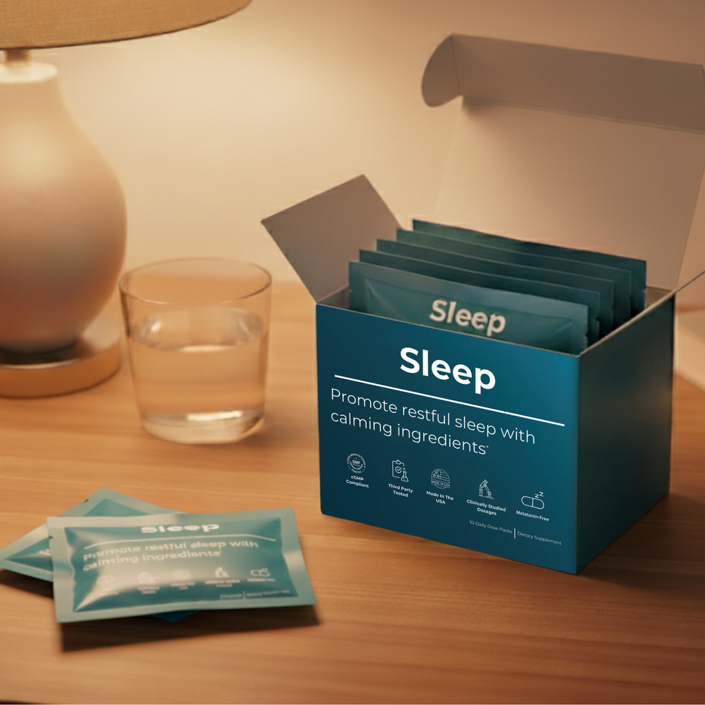 Box of 'Sleep' products on a table with a glass of water and lamp in the background