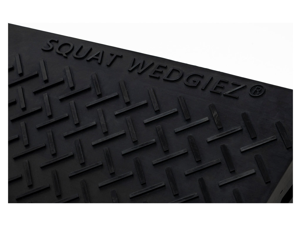 Black textured rubber mat with embossed diamond tread pattern and the brand name 'SQUAT WEDGIEZ' raised along the top edge, shown against a white background.