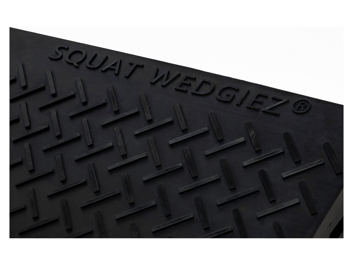Black textured rubber mat with embossed diamond tread pattern and the brand name 'SQUAT WEDGIEZ' raised along the top edge, shown against a white background.