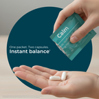 Hand holding a packet labeled 'Calm' with two capsules on an open palm against a blue circle background.