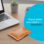 Orange packet on a desk with laptop, mug, and plant, featuring text 'Focus when you need it - anywhere'.