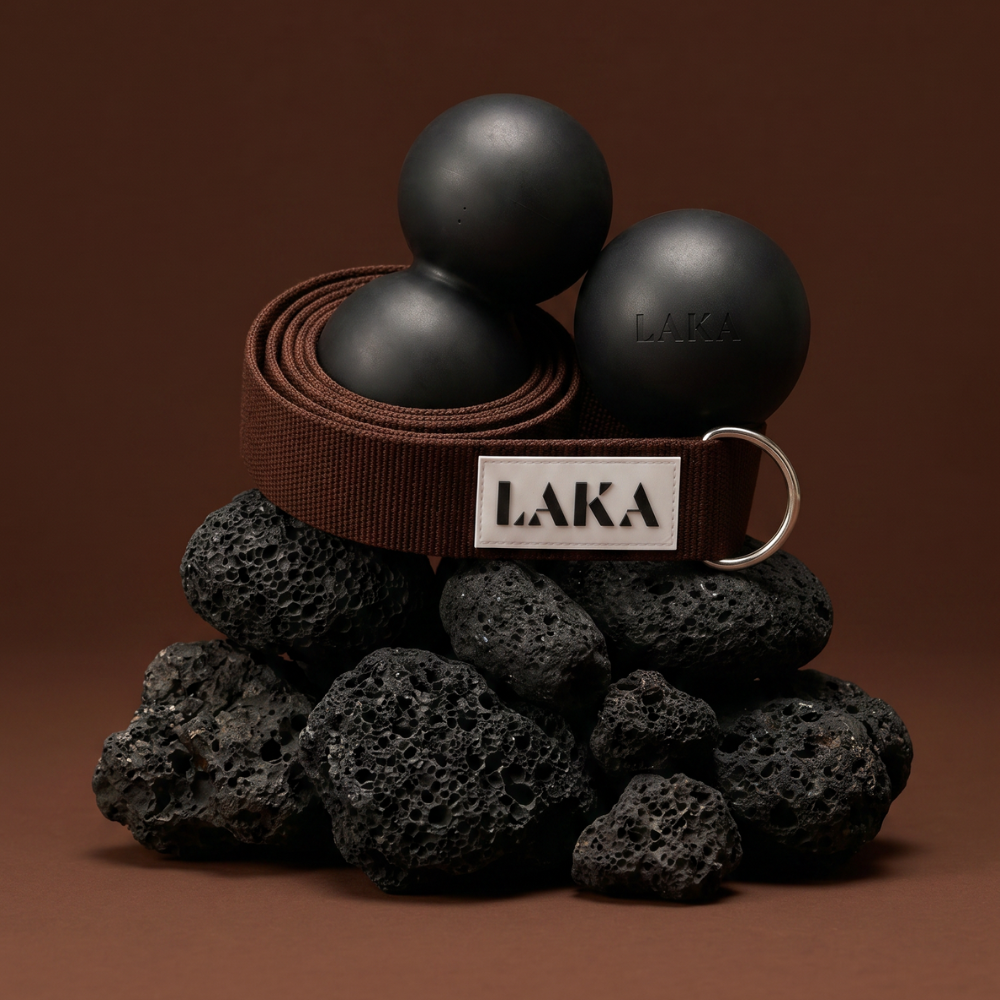 Black exercise balls and brown belt with 'LAKA' logo on a brown background