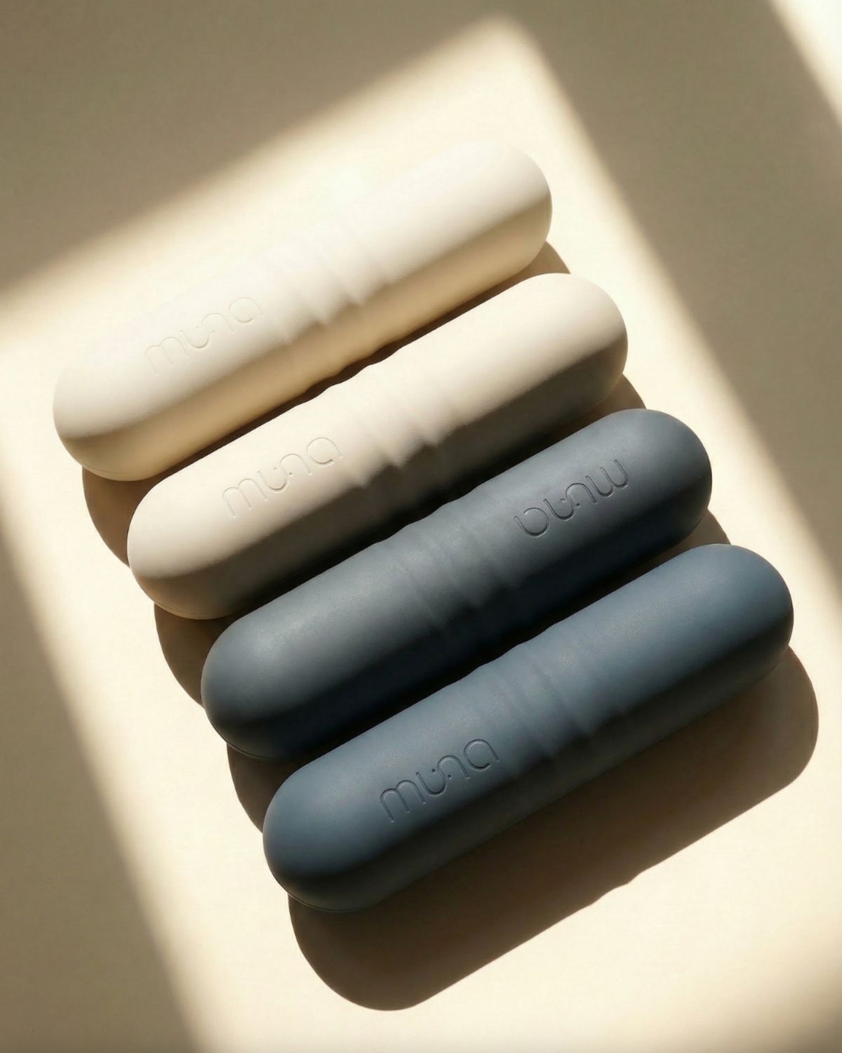 Set of four cylindrical silicone products with 'muji' branding on a light background
