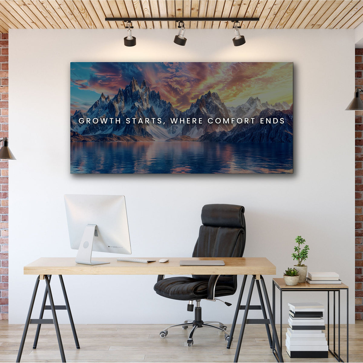 Modern office setup with a motivational quote on a mountain landscape painting.