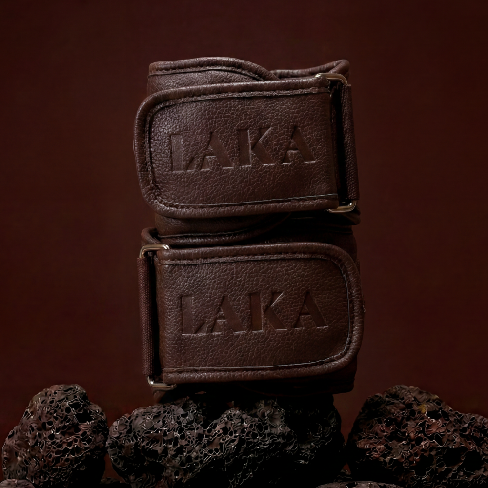 Two brown leather belts with 'LAKA' branding on a dark brown background.