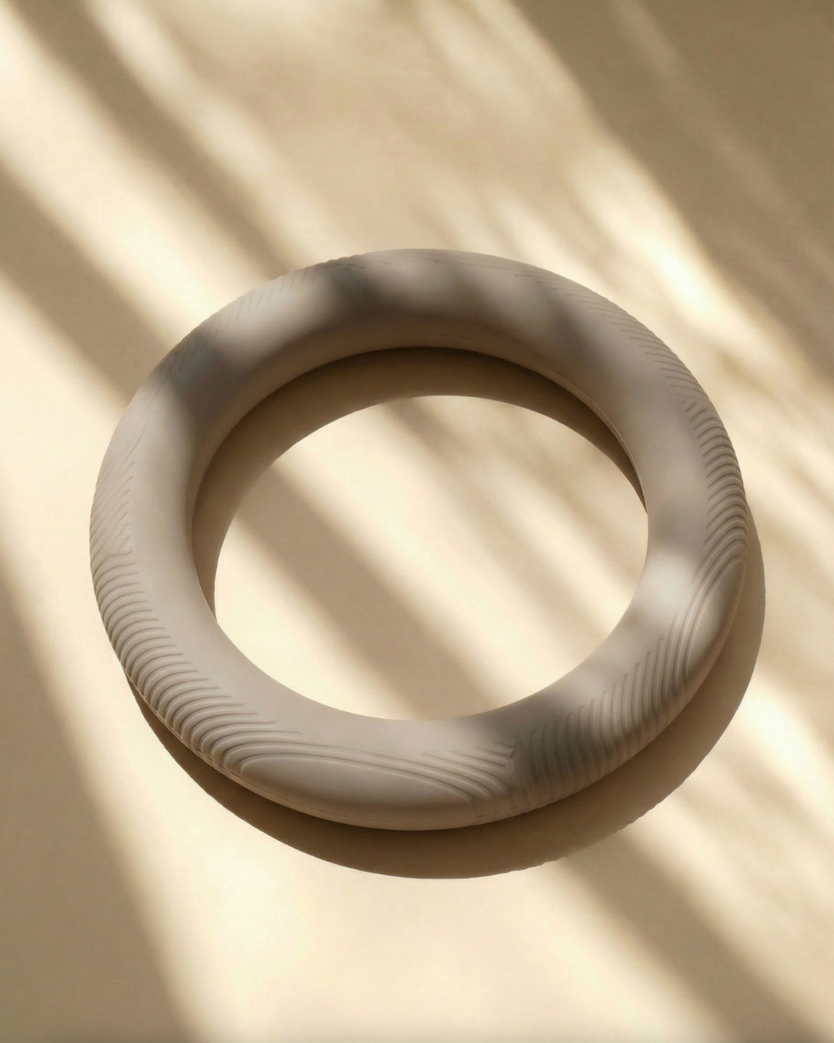 Two beige ceramic rings on a beige background