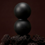 Two black spheres stacked on top of each other with a dark brown background
