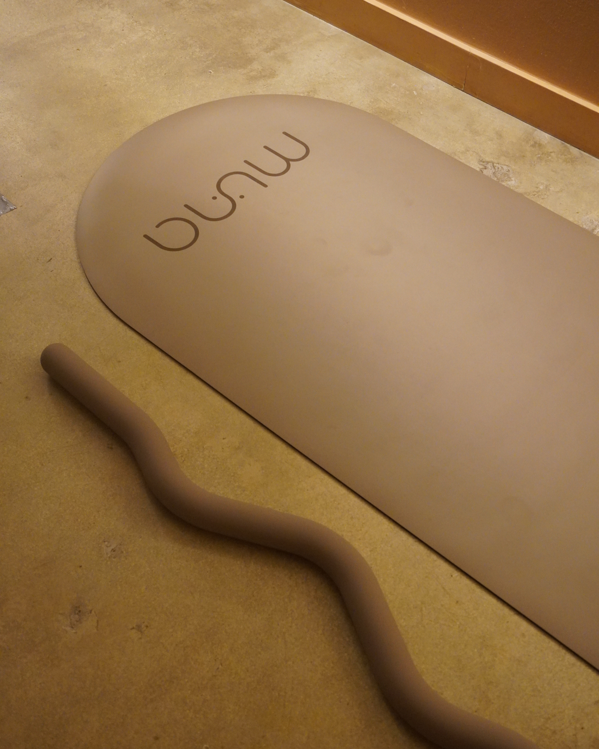 Beige oval mat with 'mug' text on a beige floor