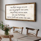 Wooden framed quote on a wall above a dining table with chairs.