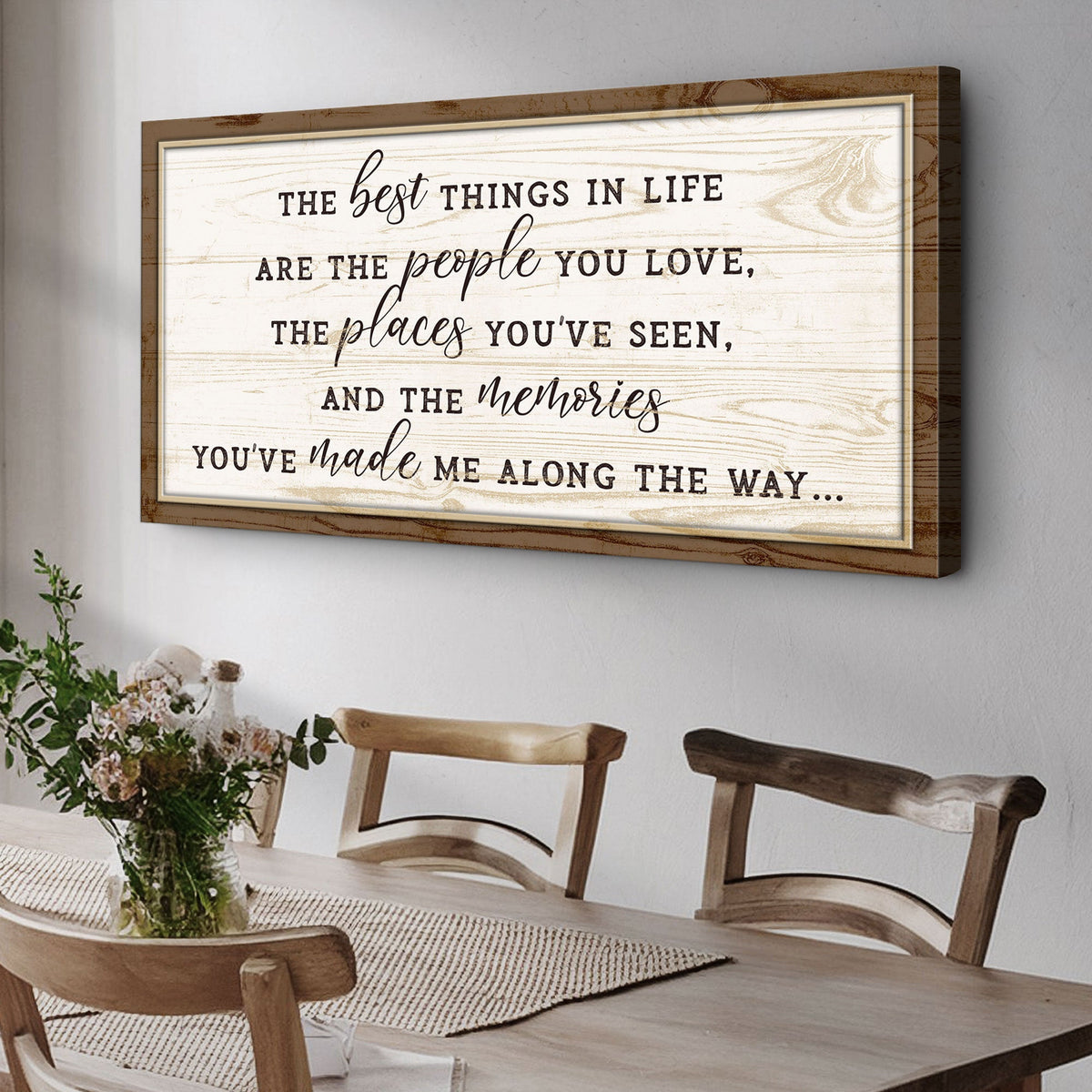Wooden framed quote on a wall above a dining table with chairs.