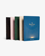 Set of five journals with different colored covers on a white background