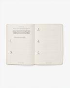 Open notebook with numbered pages on a white background