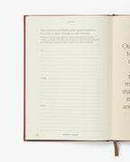 Open book with text and a red binding on a white background