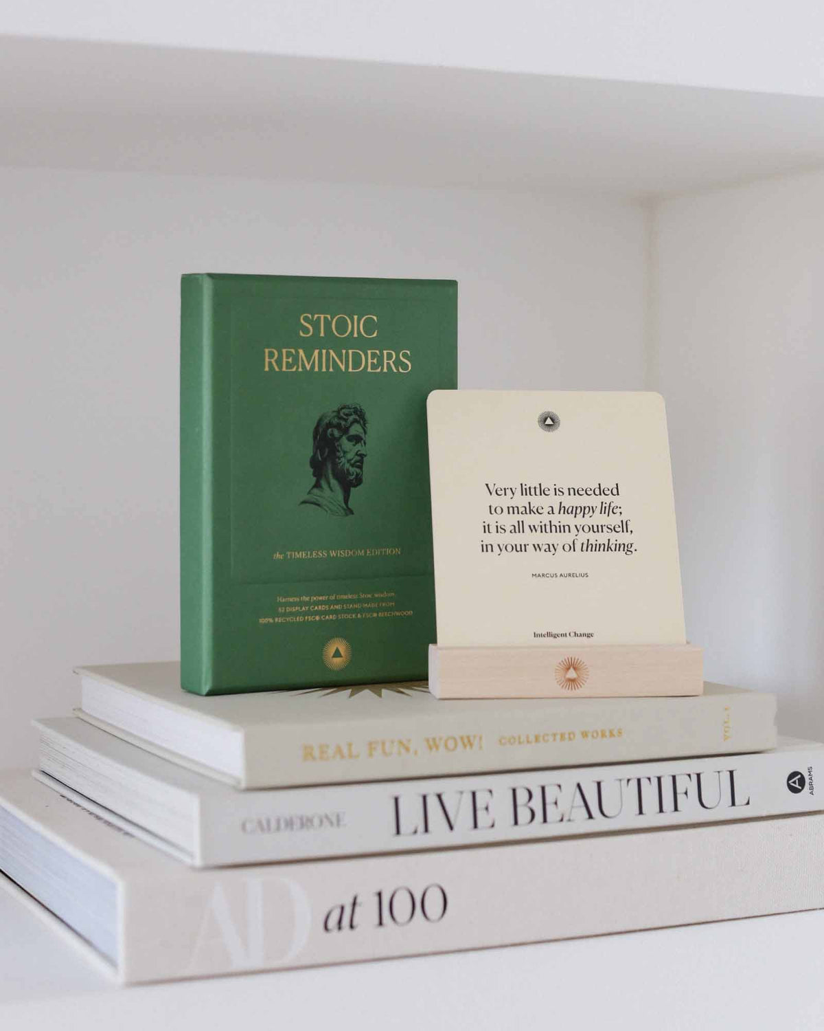Stack of books on a white shelf with visible titles and authors.