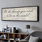 Framed Mahatma Gandhi quote on a wall in a living room setting.