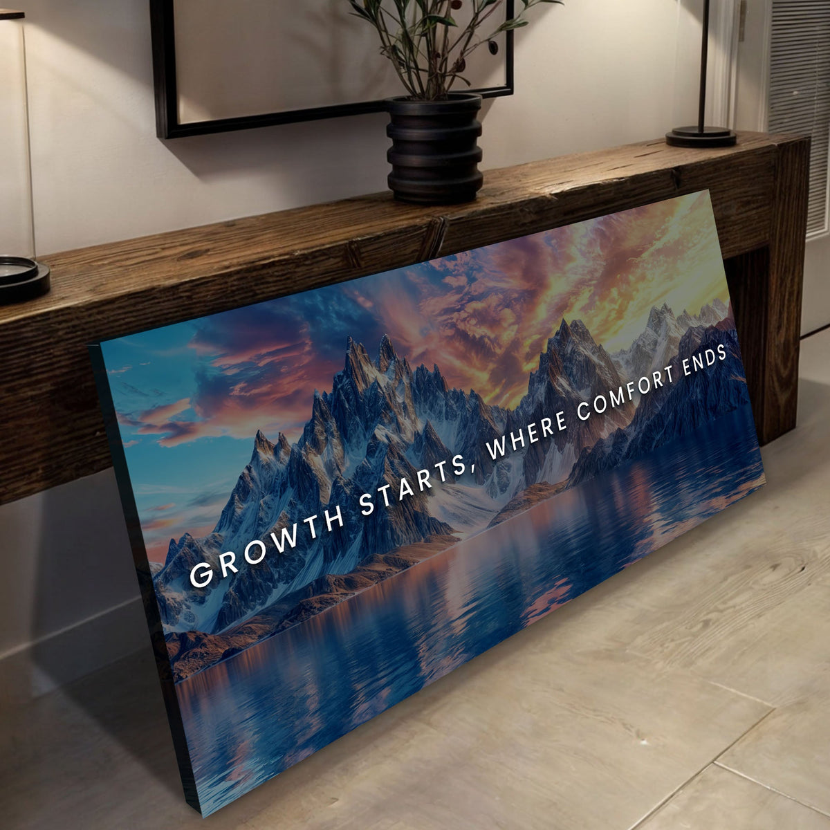 Mountain landscape poster with motivational quote on a wooden surface.