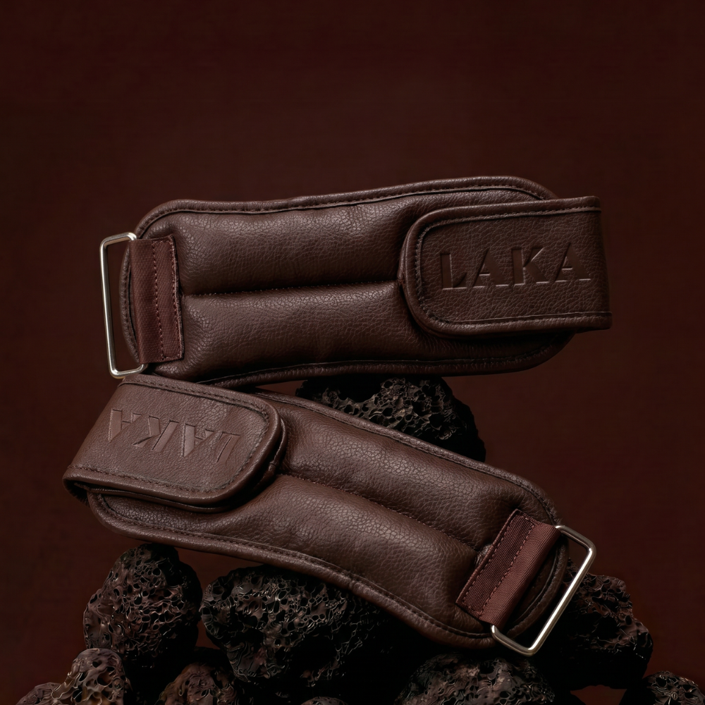 Brown leather belt with 'LAKA' branding on a dark brown background