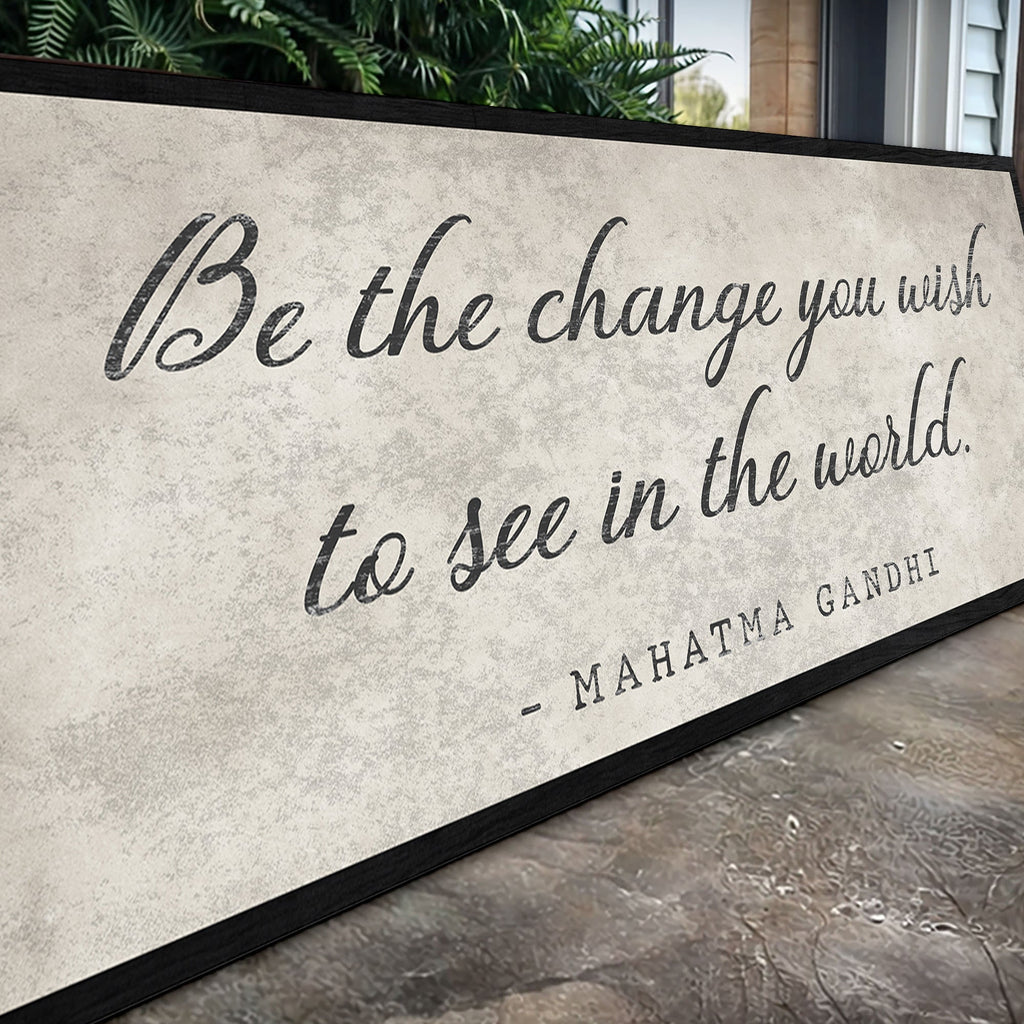 Decorative wall art with Gandhi quote on a textured surface