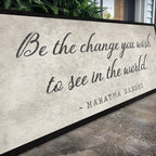 Decorative wall art with Gandhi quote on a textured surface