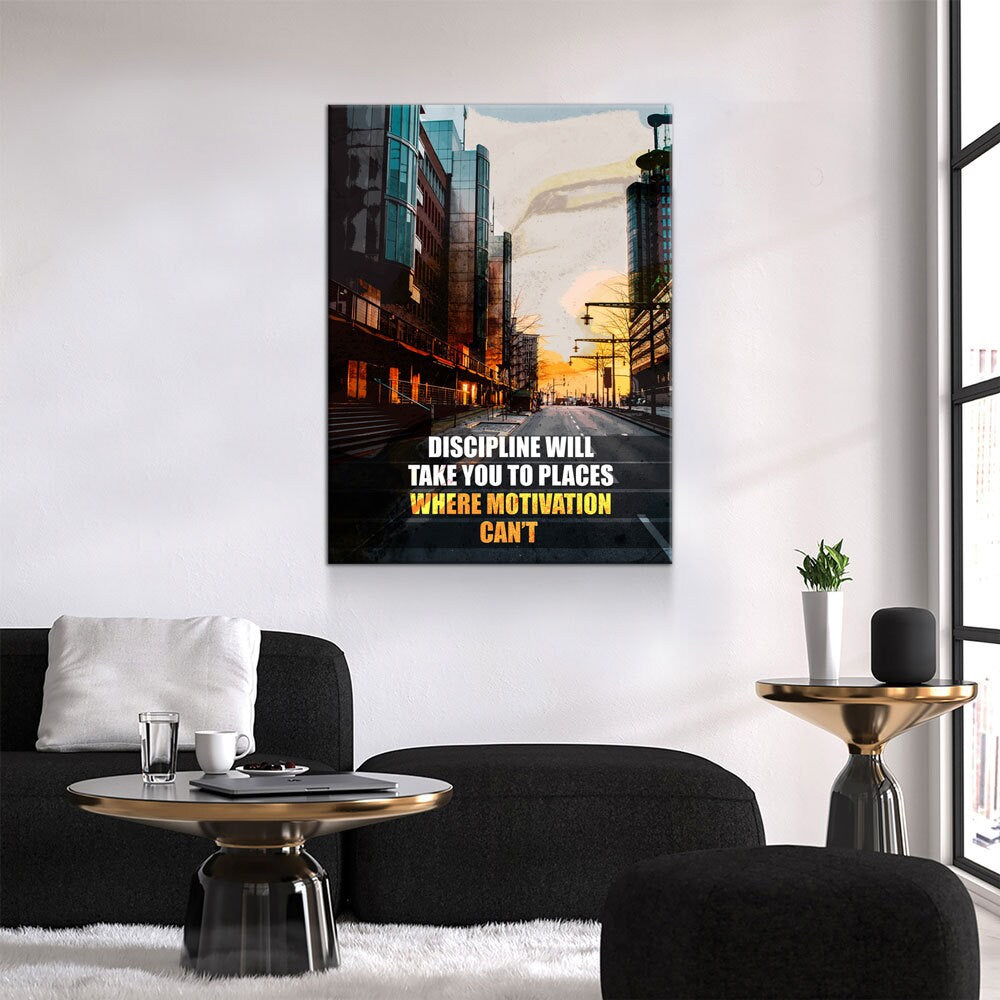 Living room with a motivational poster on the wall, black sofa, and small table with a plant.