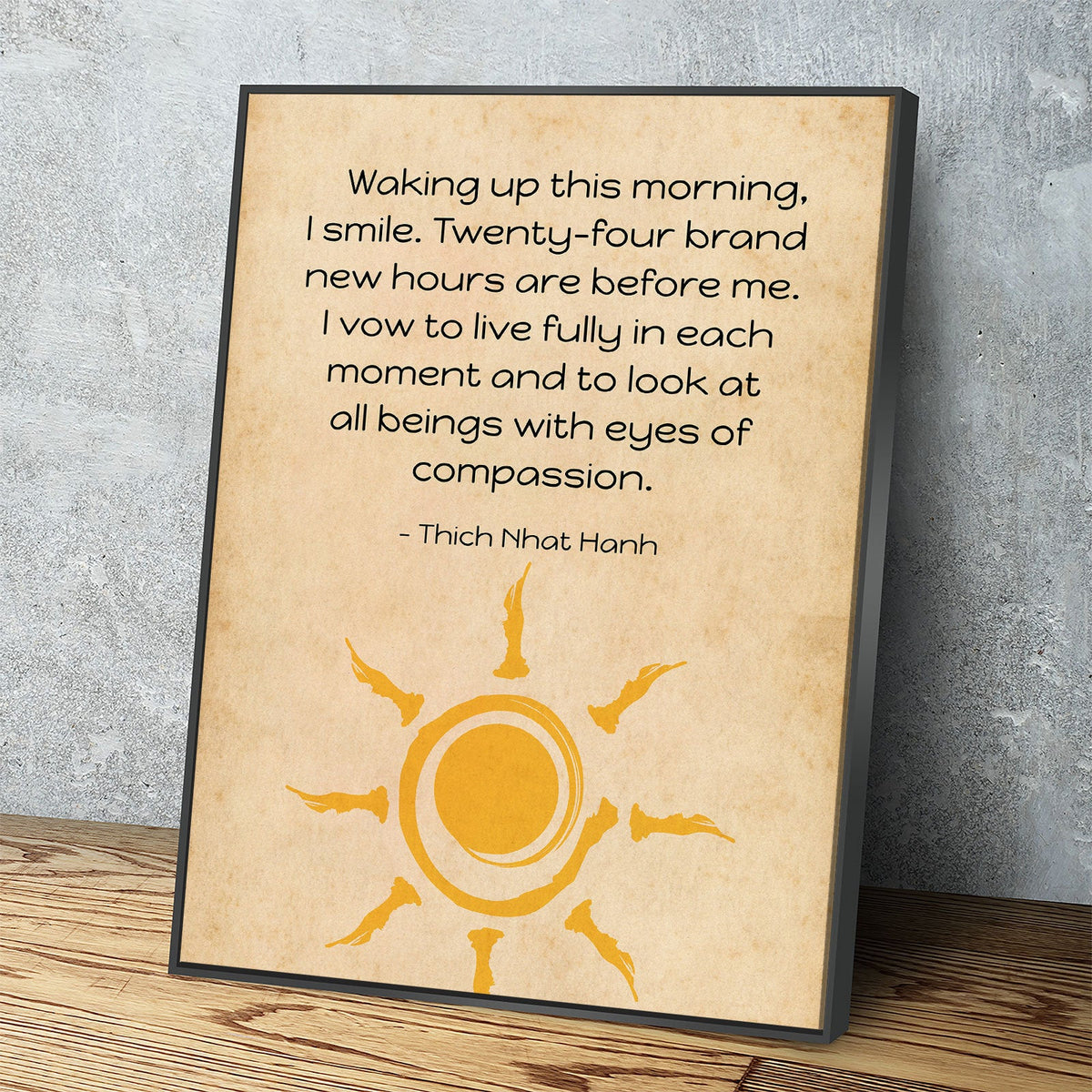Framed quote by Thich Nhat Hanh with a sun design on a wooden surface and gray wall background