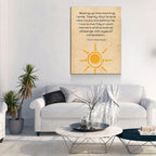 Living room with a couch, coffee table, and wall art featuring a sun design and text.
