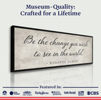 Framed artwork with Gandhi quote 'Be the change you wish to see in the world' on a white background.