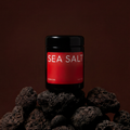 Jar of sea salt on a dark background with rocks