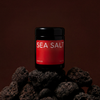Jar of sea salt on a dark background with rocks