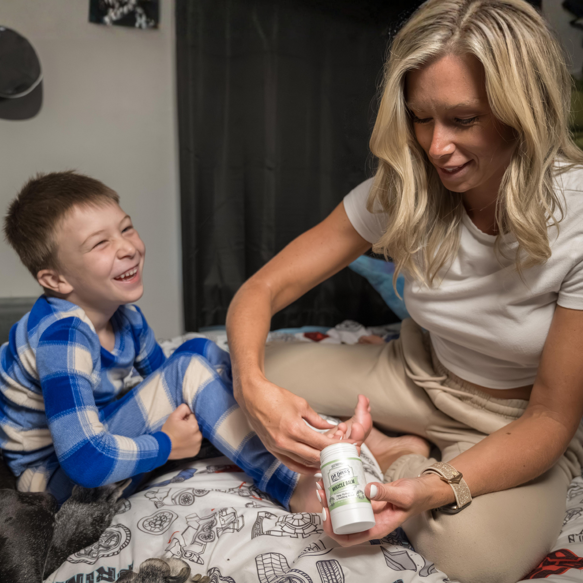 Woman and child sitting on a bed with a bottle of supplements
