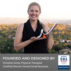 A smiling woman in a black sleeveless top holds a white curved physical therapy tool with an orange handle, set against a blurred outdoor landscape. A dark gray banner at the bottom reads 'FOUNDED AND DESIGNED BY Christine Annie, Physical Therapist.