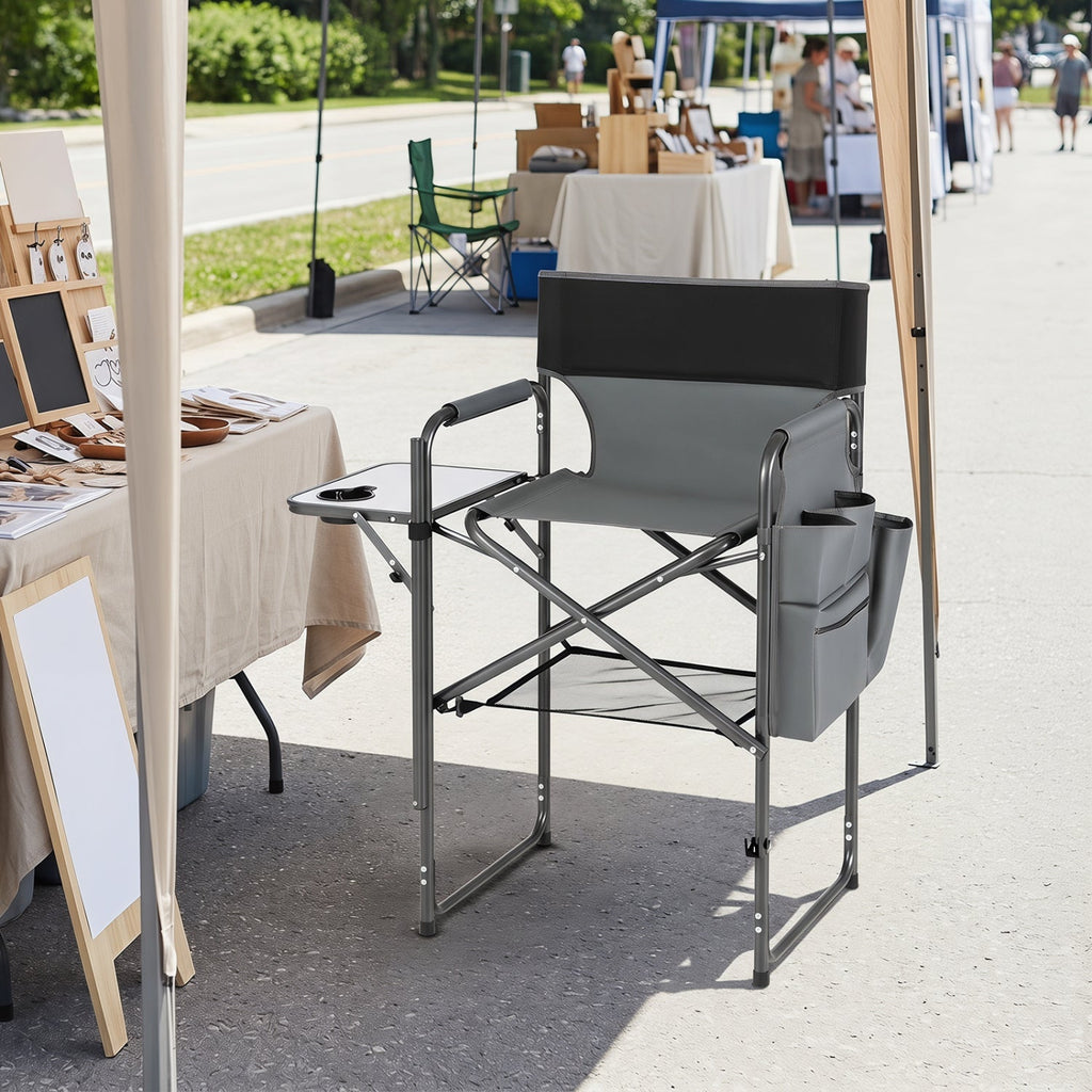 Gray director's chair with armrests on a street with outdoor furniture and tables in the background.