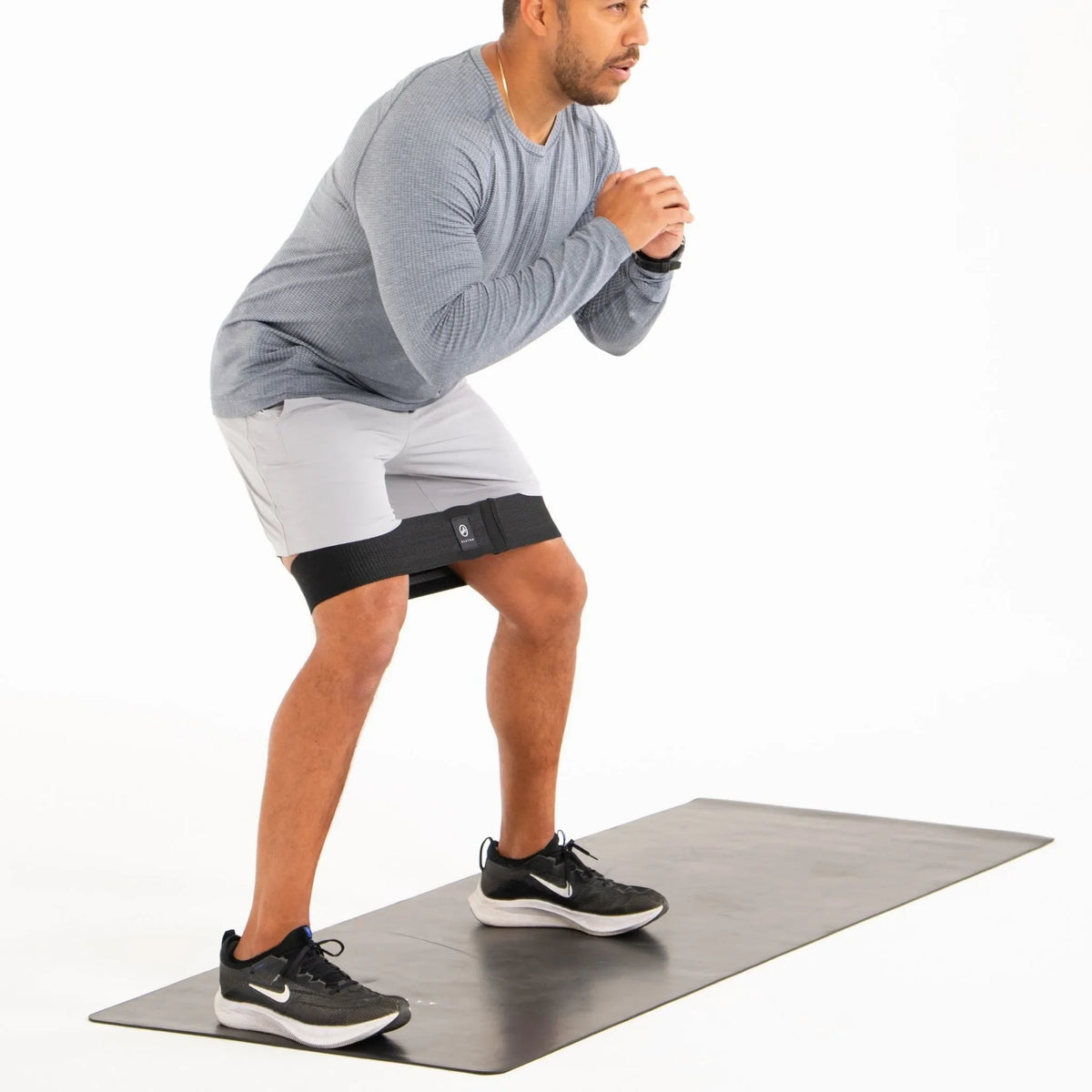 Man exercising on a mat with a white background