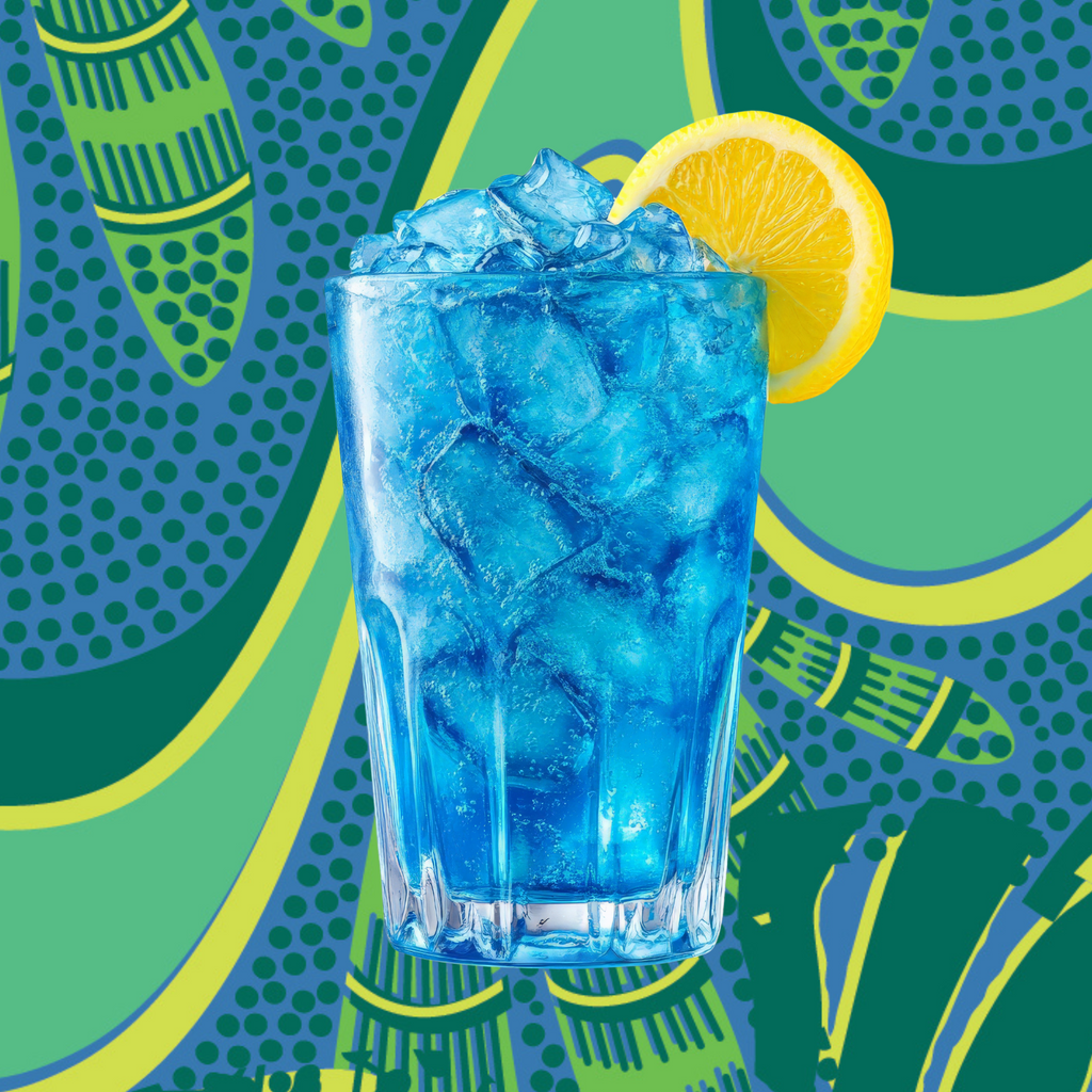 Glass of blue iced drink with a lemon wedge on a colorful patterned background