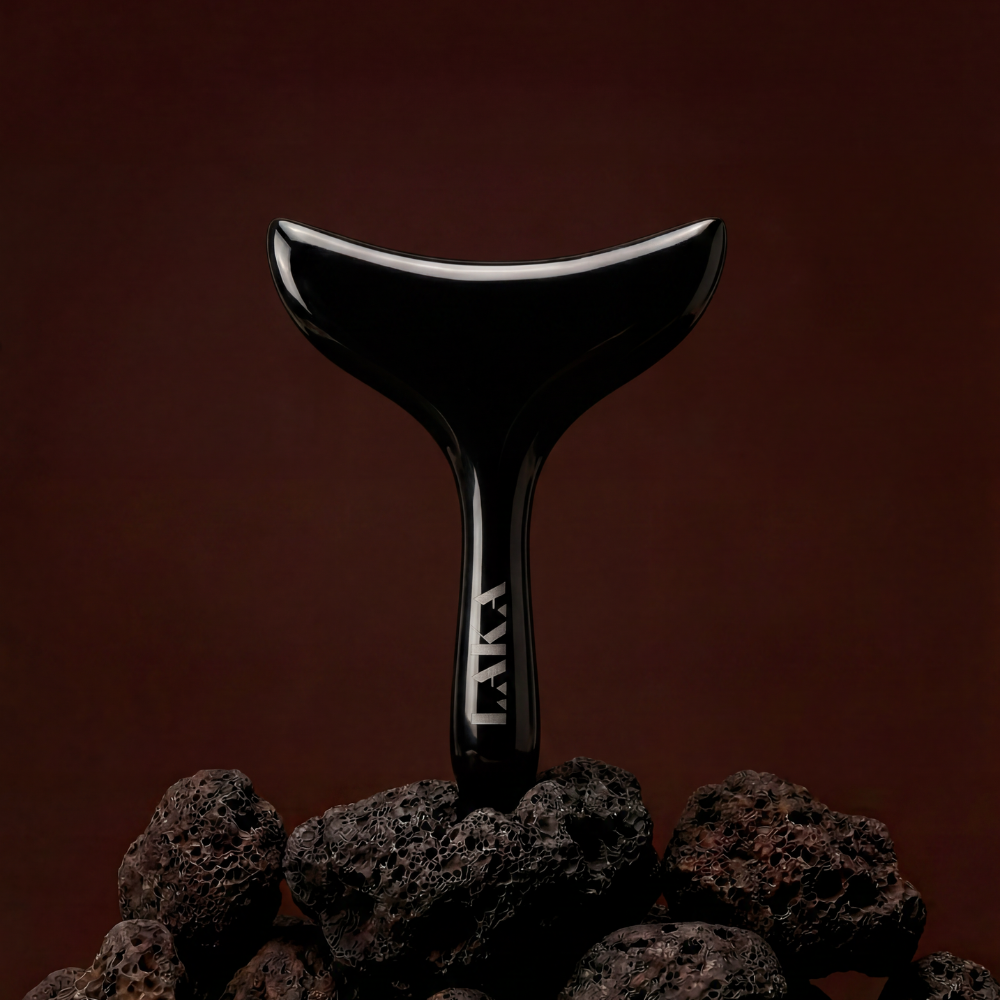 Black Bian stone massage tool with white logo on a dark brown background