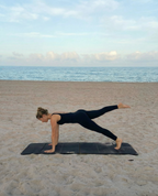 Person practicing yoga on a beach with ocean view