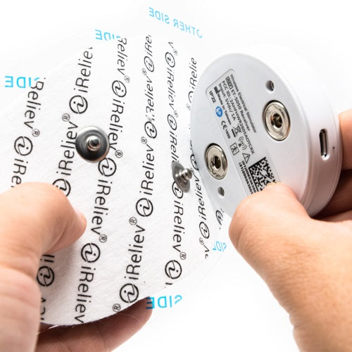 iReliev electronic device held by a hand with branding visible