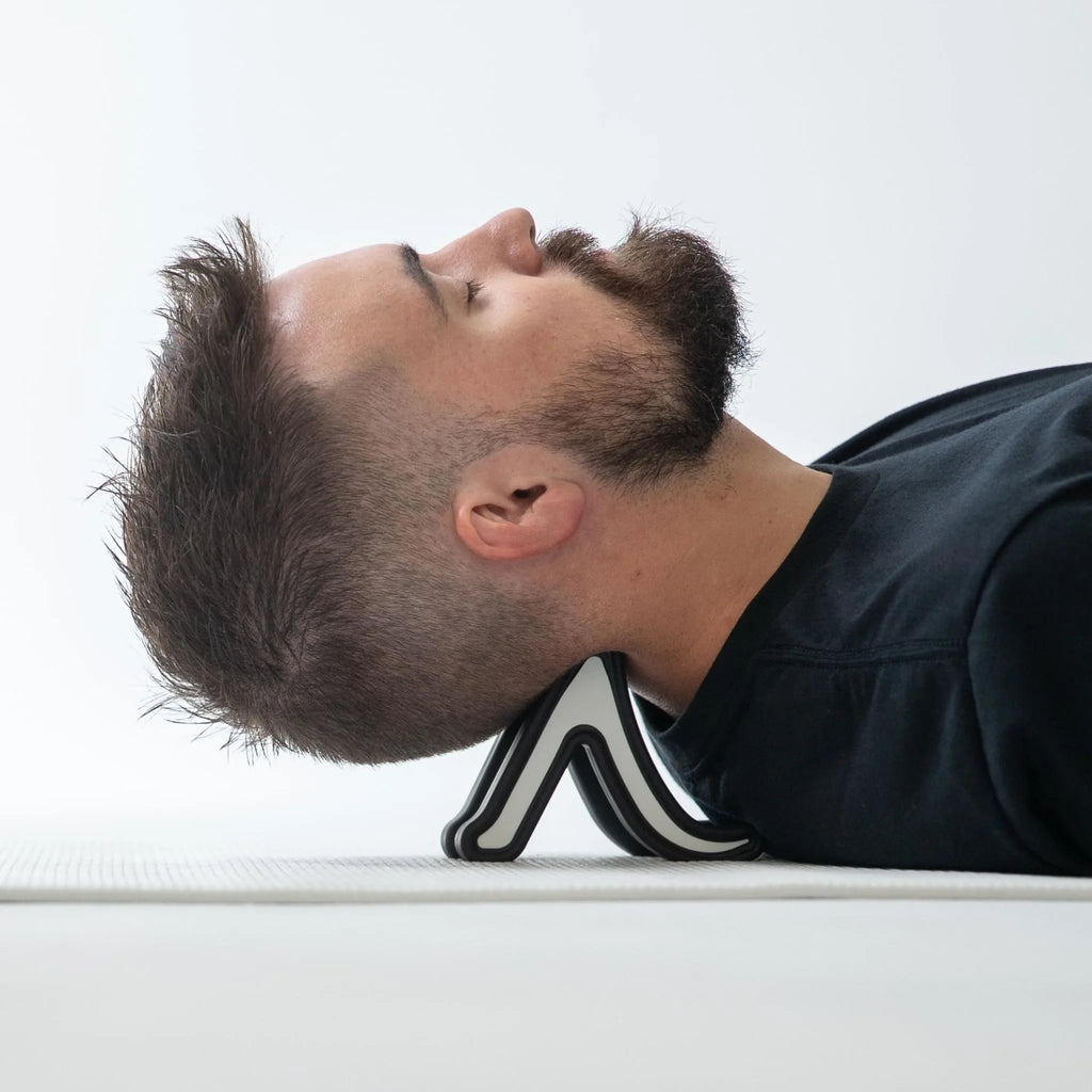 Person using a black and white shoe as a pillow on a white surface