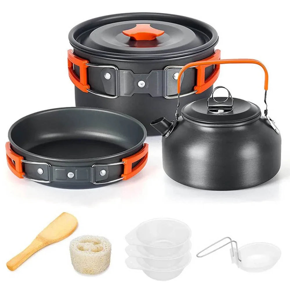 Set of camping cookware including pots, pans, and utensils on a white background