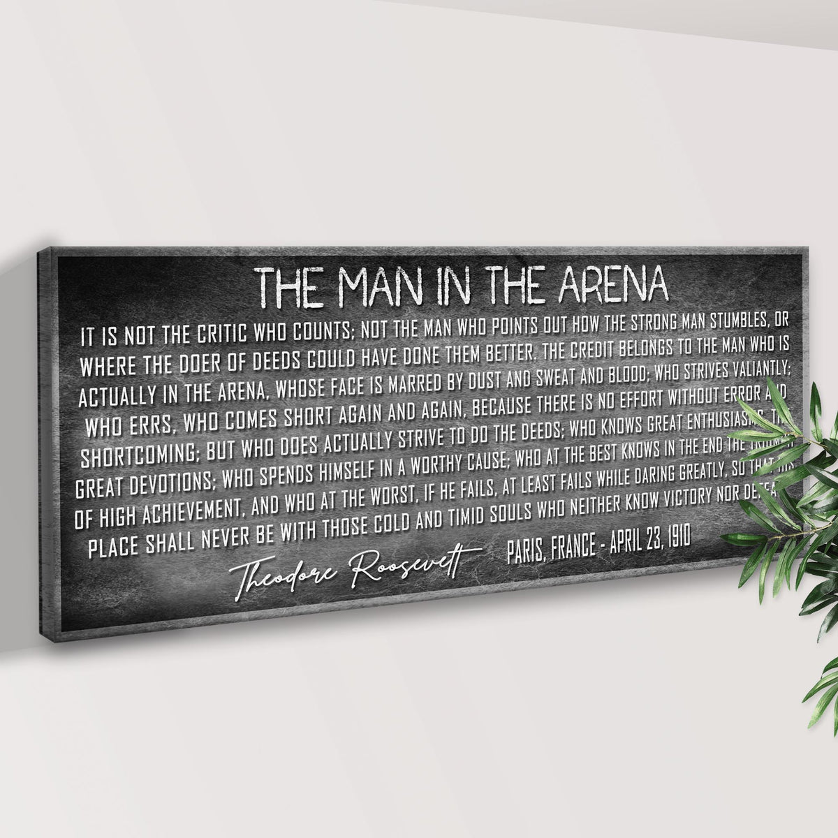 Canvas print with Theodore Roosevelt's 'The Man in the Arena' quote on a white wall.