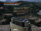 Fenix flashlight with rotary switches and top electronic switch on a blurred natural background