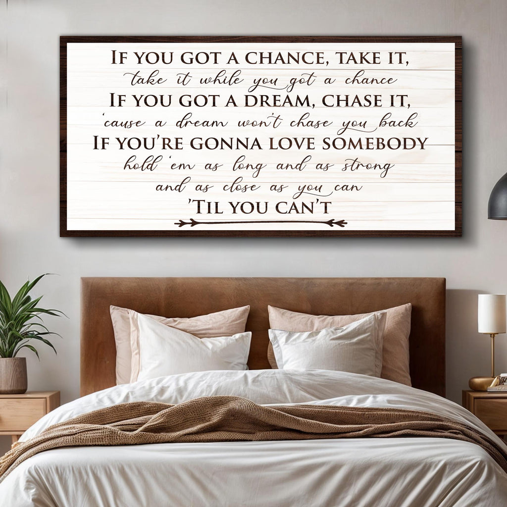 Framed motivational quote above a bed in a bedroom setting