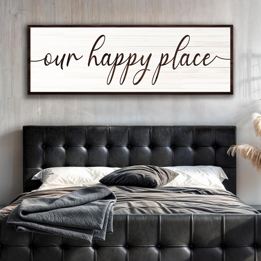 Bedroom with black tufted headboard and 'our happy place' wall art