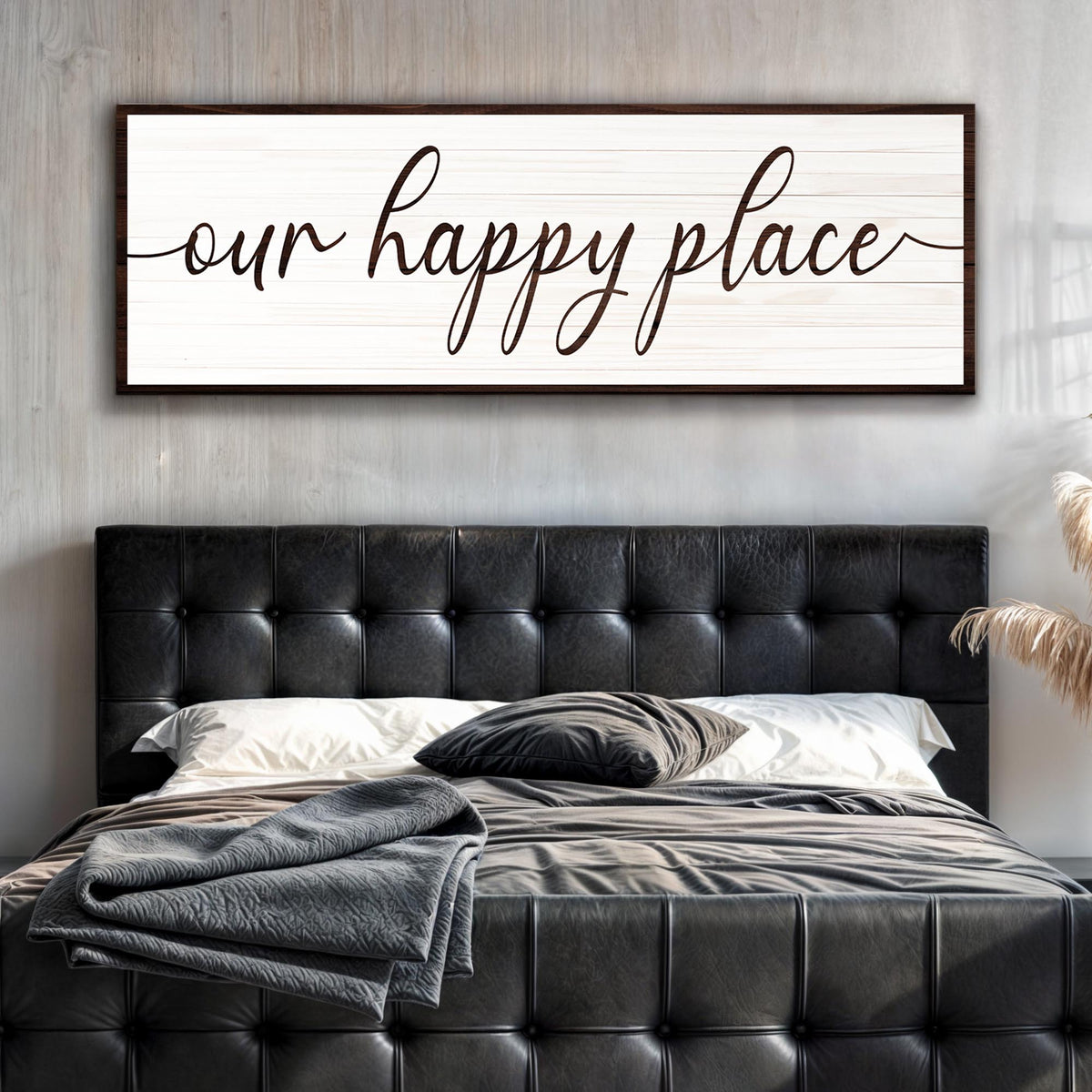 Bedroom with black tufted headboard and 'our happy place' wall art