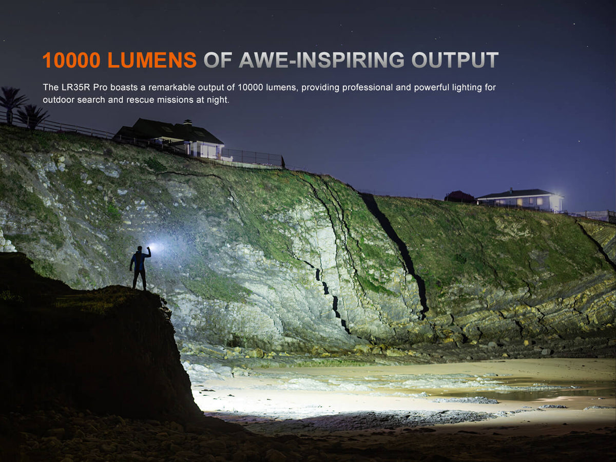 Person with a flashlight on a cliffside at night, illuminating a coastal area.