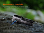 Flashlight with USB cable on a rock, highlighting fast charging feature.
