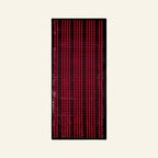 A rectangular black LED light bar or sign with multiple vertical rows of glowing red and pink dots, centered on a light cream background.